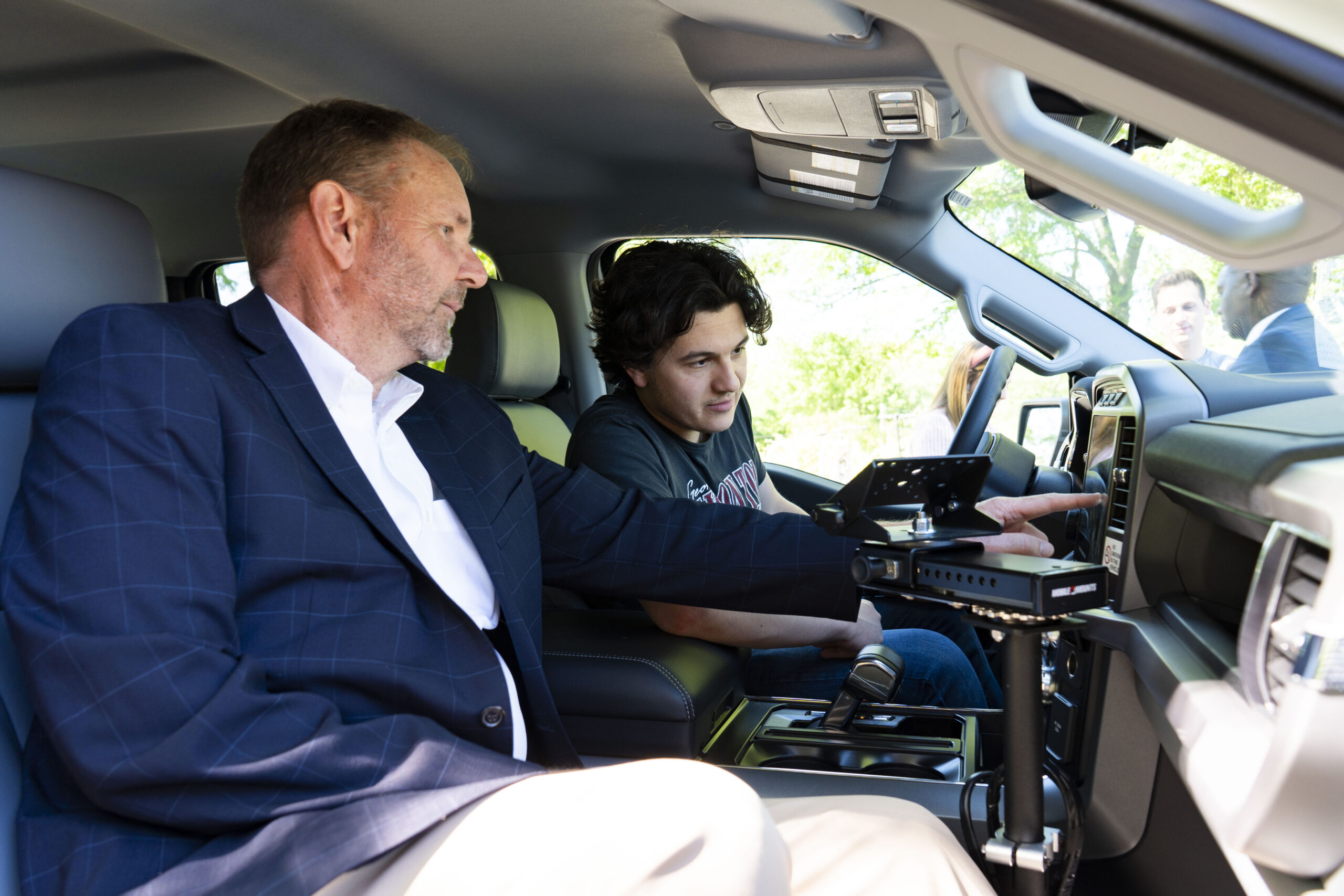 Georgia Power representative checking out an electric vehicle with a student